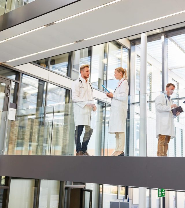 Ärzte Team bei einer Besprechung oder beim Briefing auf einer Galerie im Krankenhaus